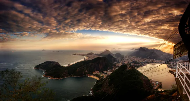Panorama da cidade do Rio de Janeiro, da baía e das montanhas ao entardecer.