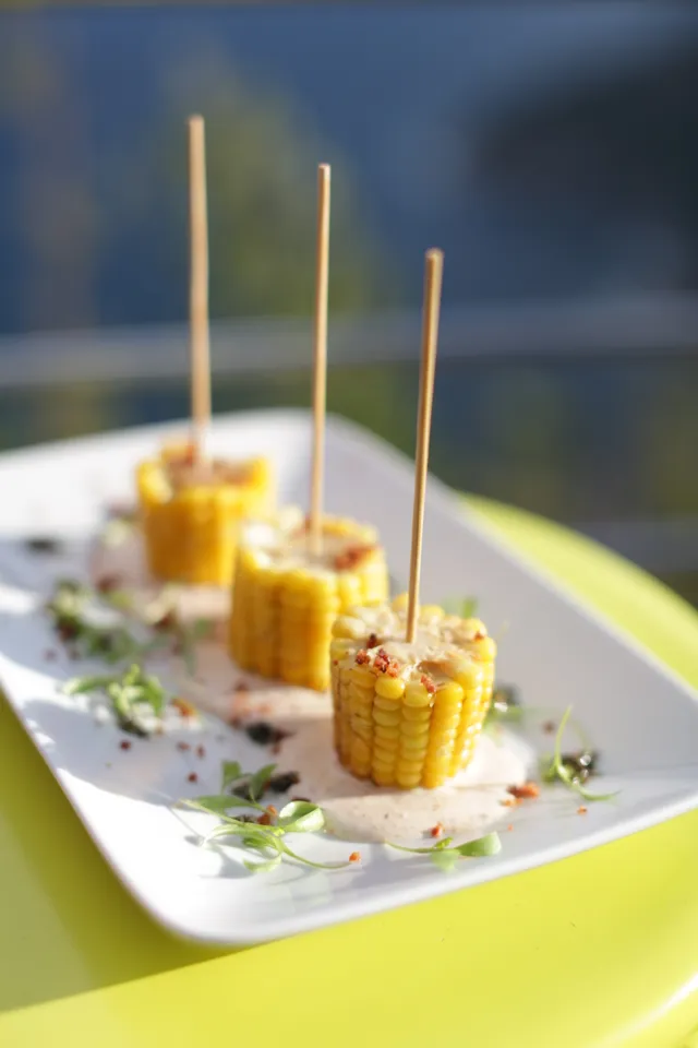 Pequenas porções servidas com palitos em uma travessa branca.