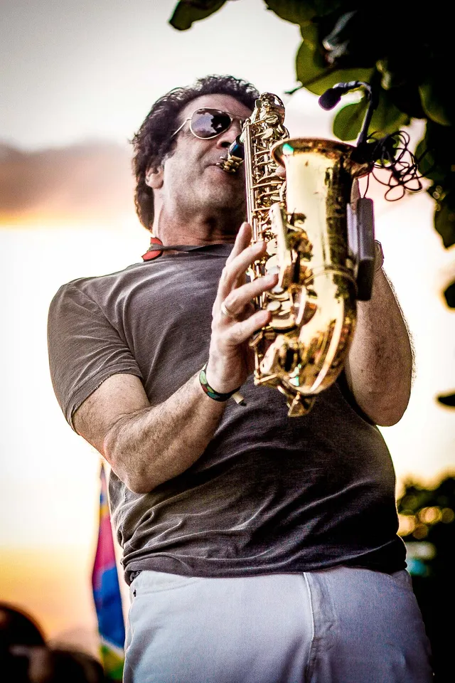 Músico tocando saxofone ao ar livre.