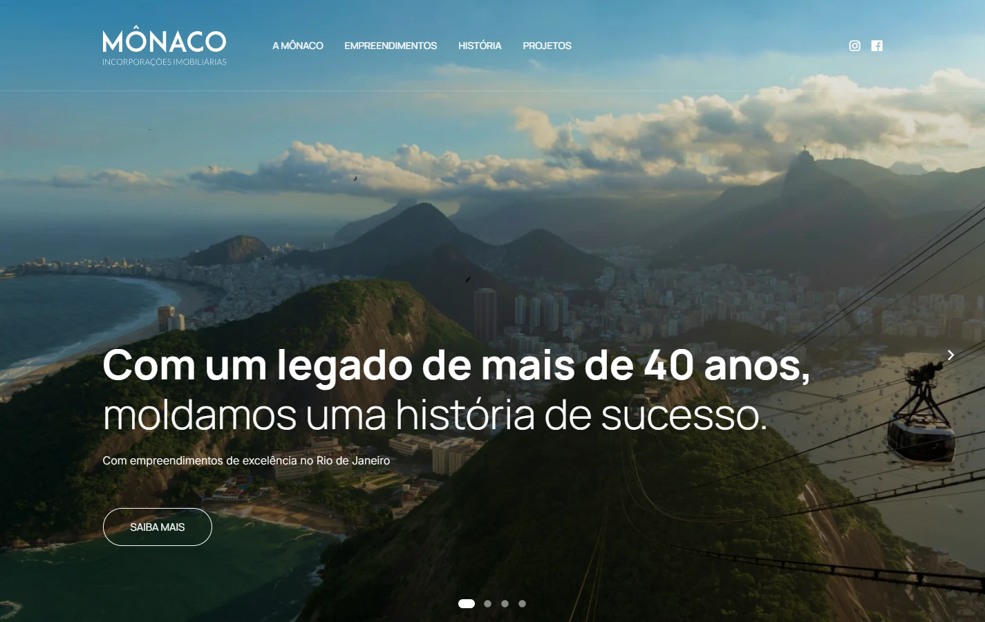 Abertura desktop da Mônaco com marca, navegação institucional e paisagem do Rio de Janeiro ao fundo.