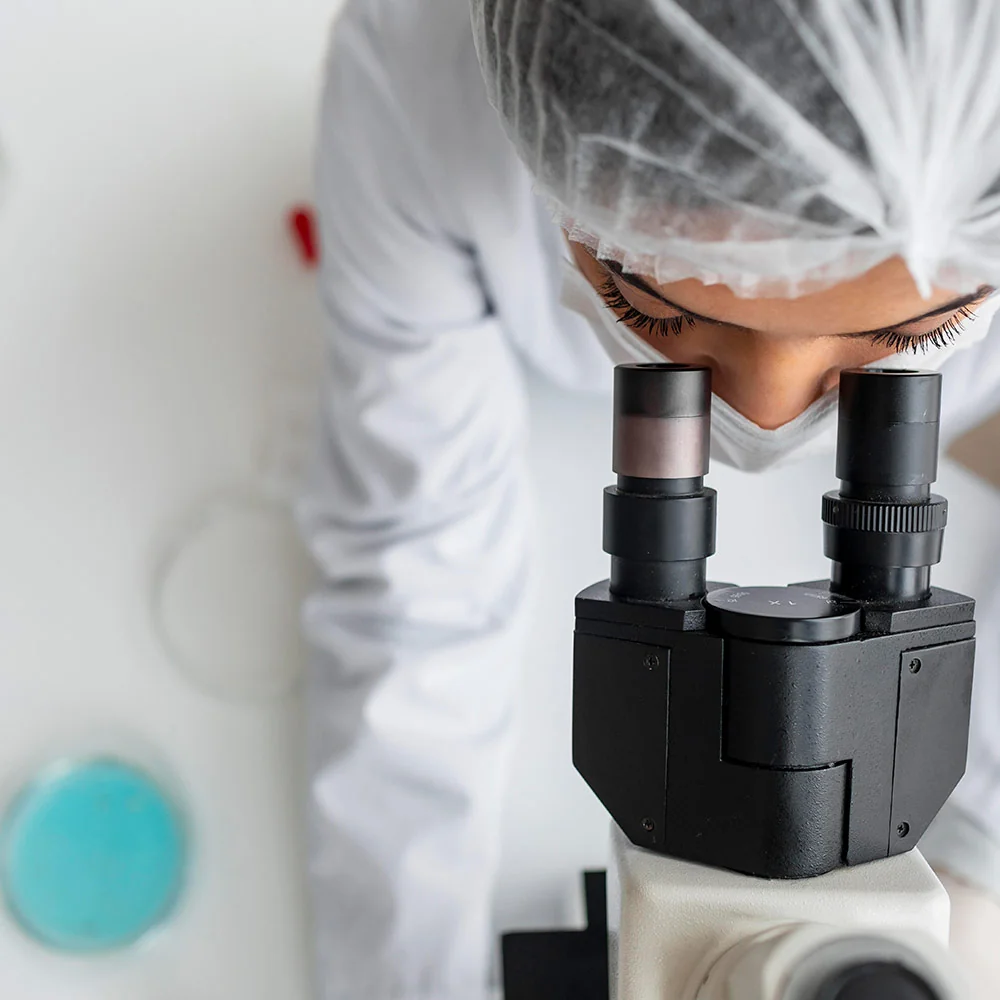 Profissional de laboratório utilizando um microscópio.