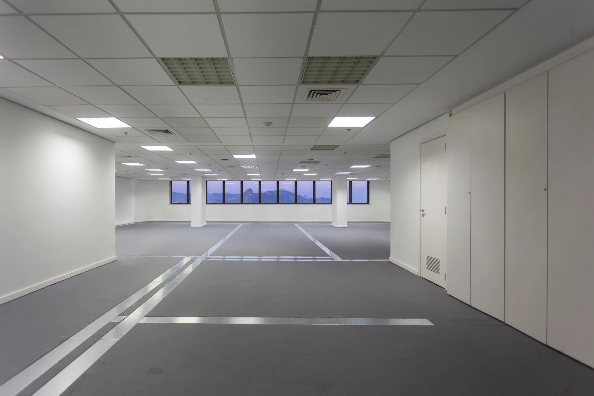 Sala comercial do Park Towers, com planta aberta e janelas ao fundo.
