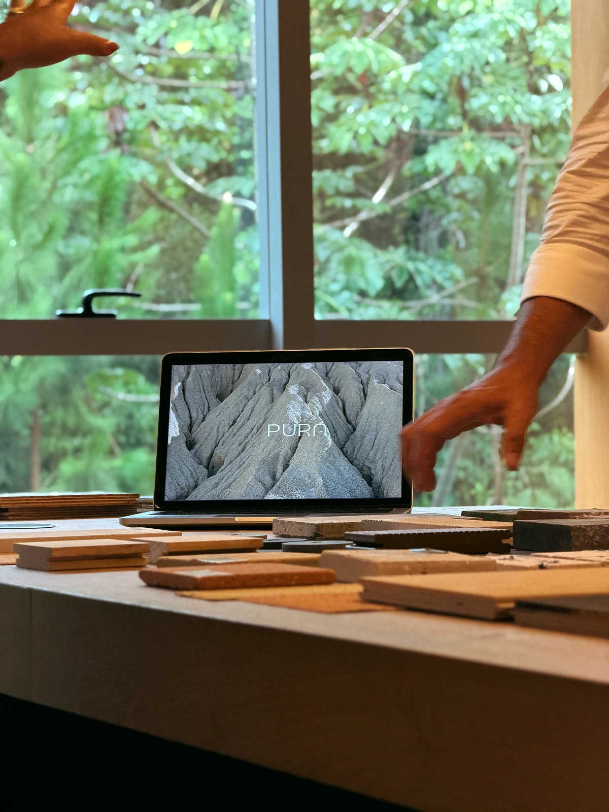 Tablet com a marca Pura ao lado de amostras de revestimentos.
