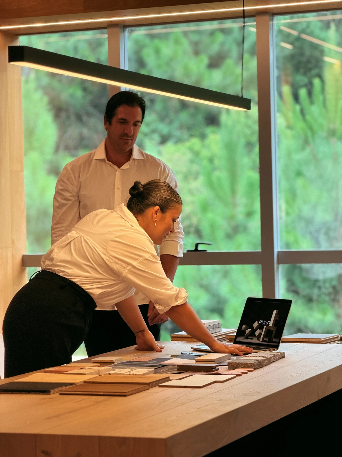Duas pessoas examinando materiais e a apresentação da Pura em uma mesa.